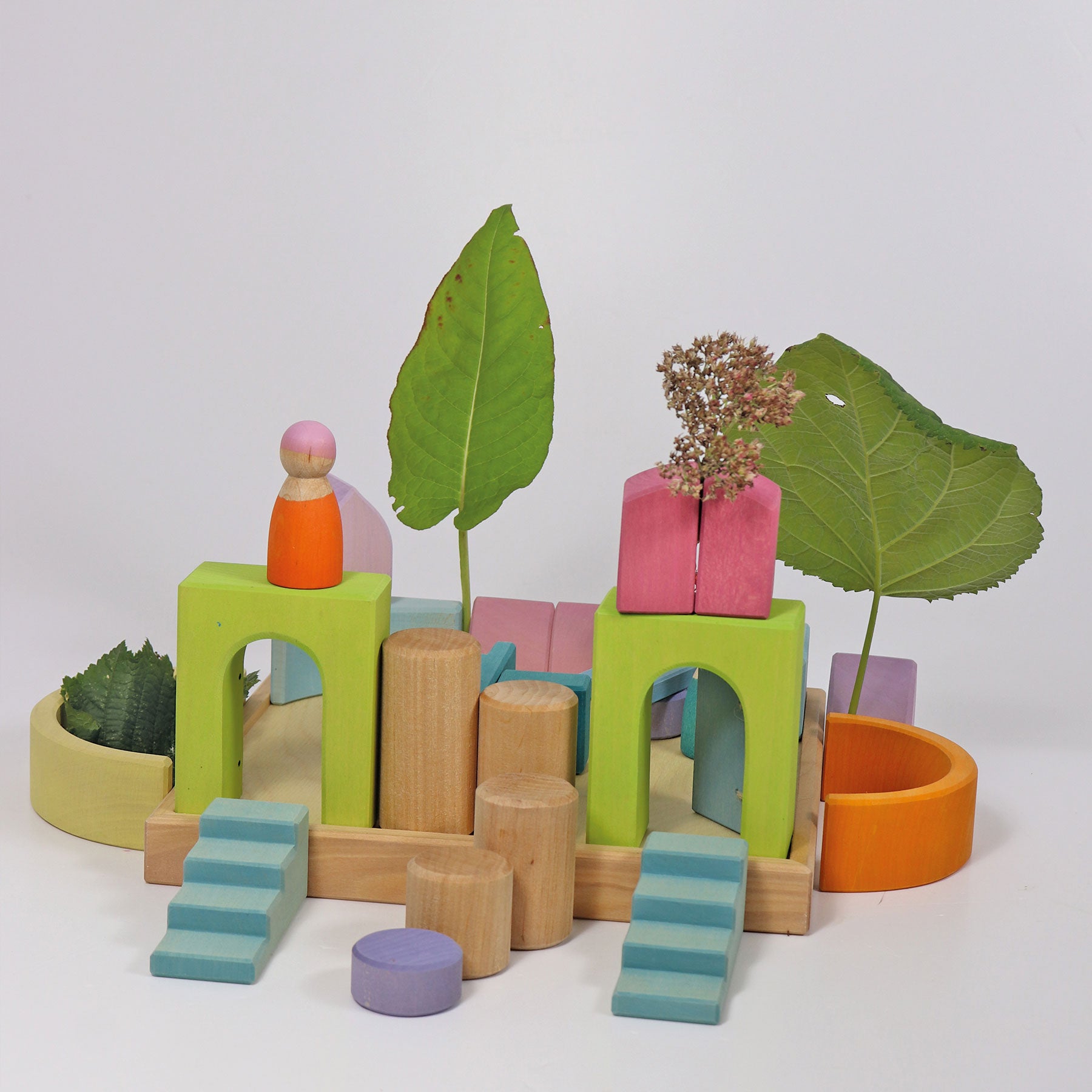 Colorful wooden toy blocks and plant pots on a white background