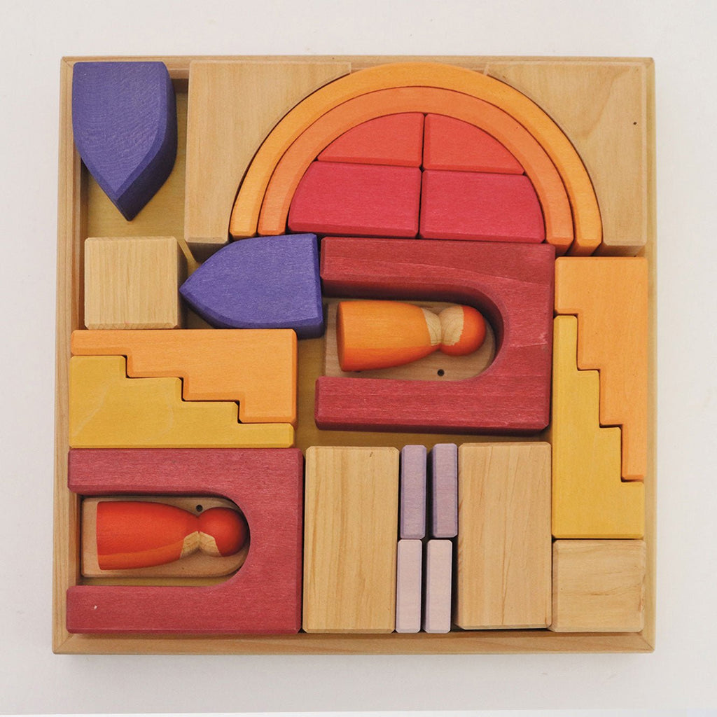Colorful wooden puzzle blocks in a box on a white background