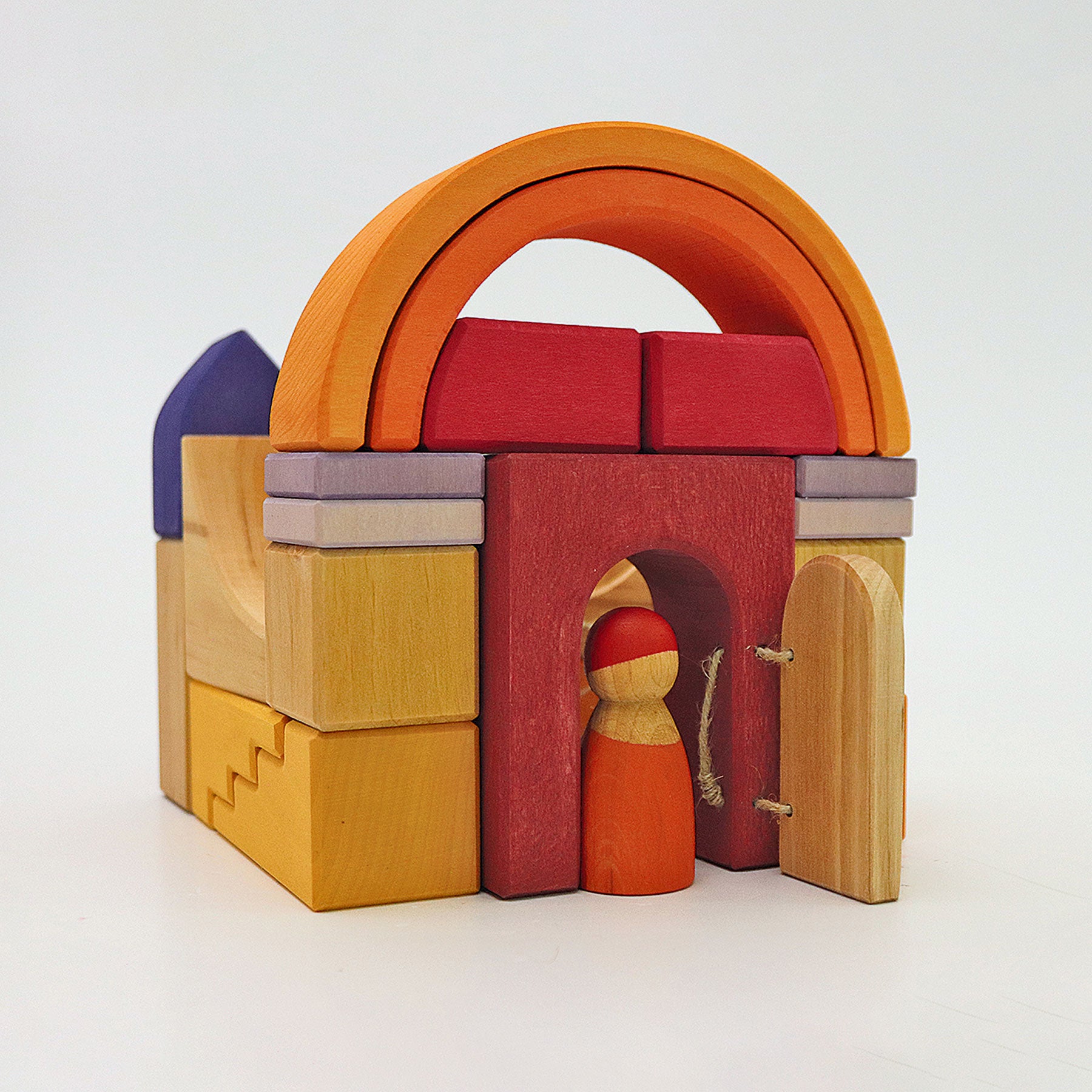 Colorful wooden toy set with arches and a small figure on a white background