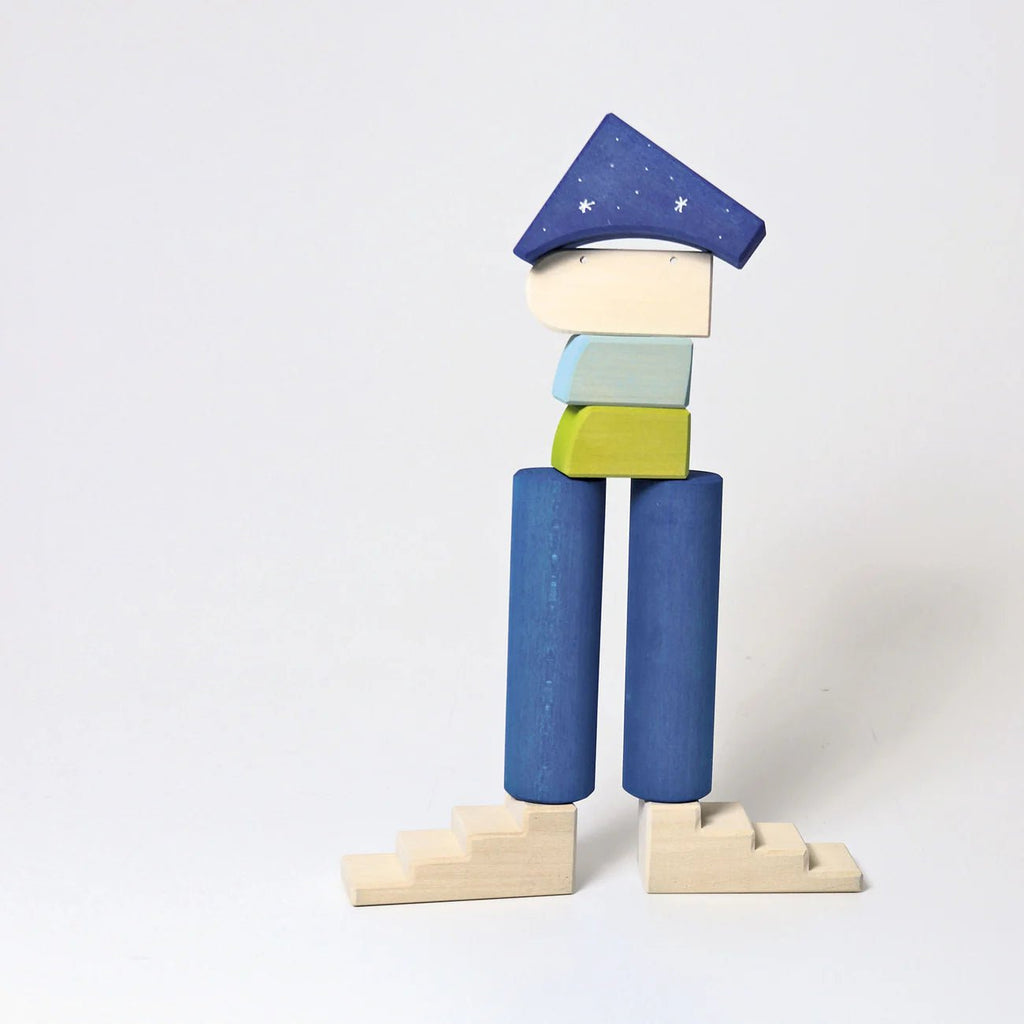 Wooden toy figure with a blue hat and pants on a white background