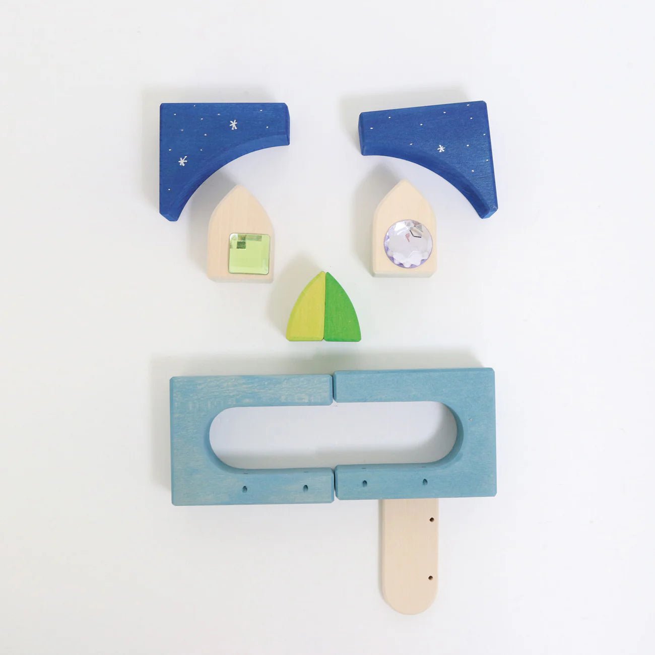 Set of wooden toys including a blue house, green triangle, and a popsicle stick on a white background