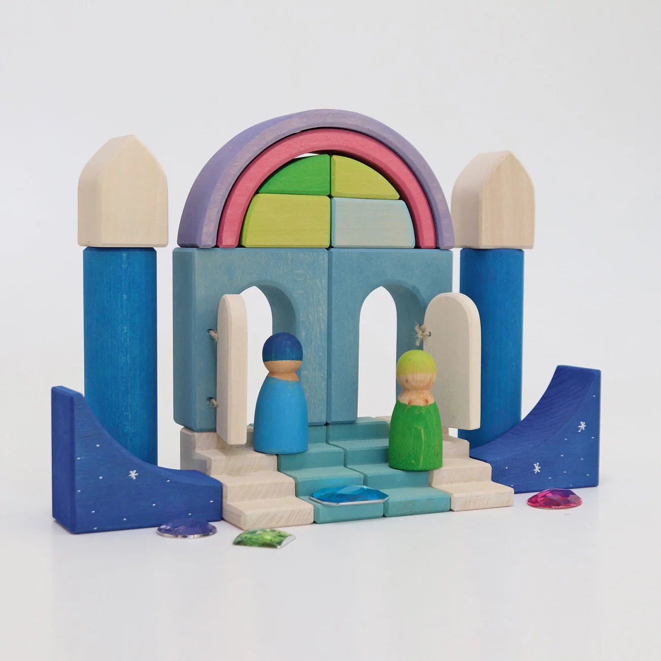 Wooden nativity set with colorful arch and stable on a white background