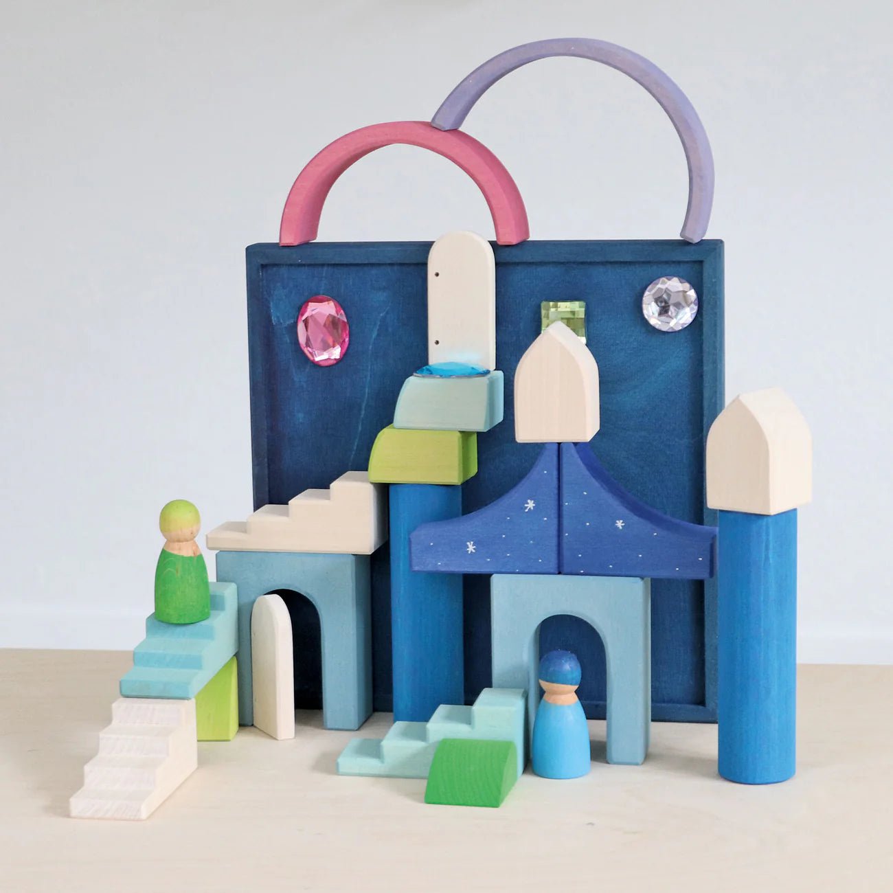 Colorful wooden toy set with arches and figures on a light background