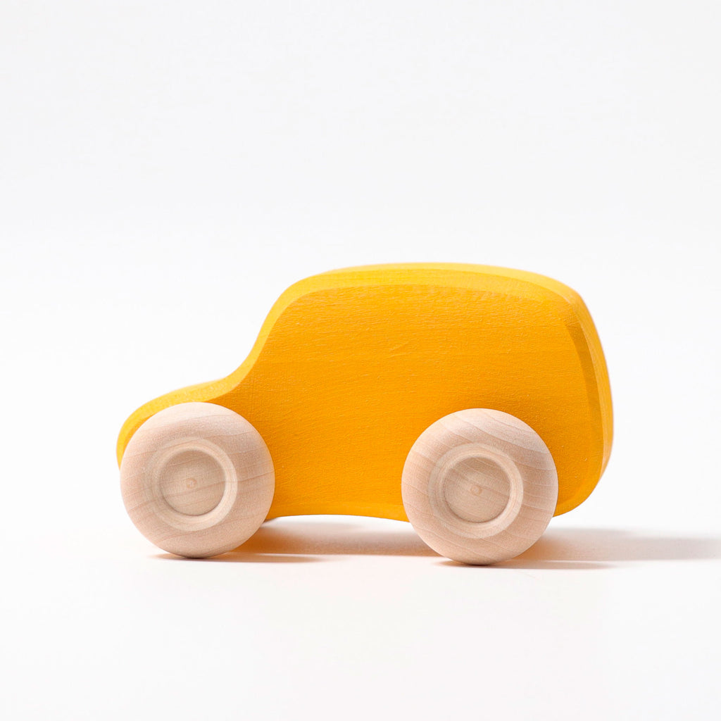 Yellow toy car with wooden wheels on a white background