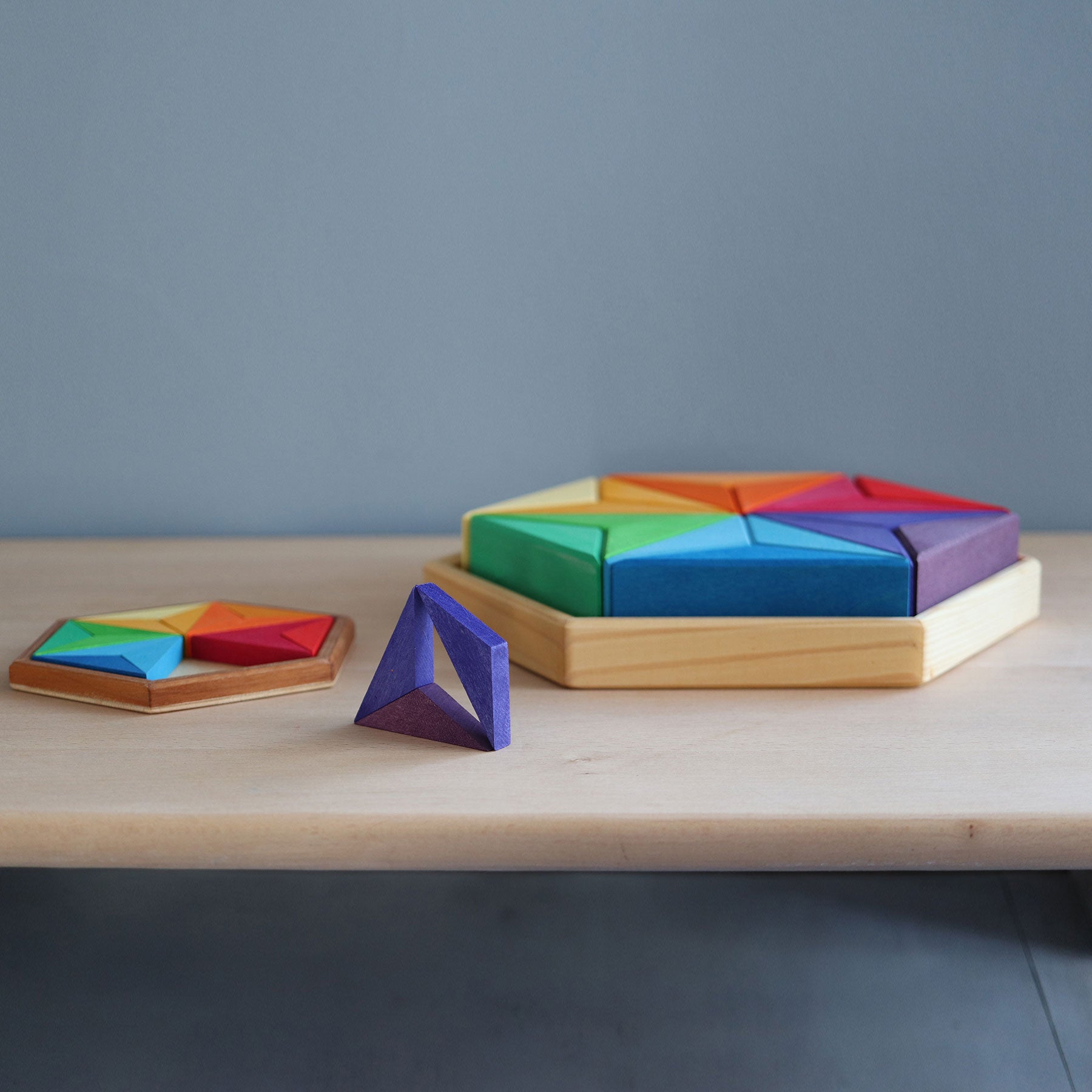 Colorful geometric shapes on a wooden base against a gray background