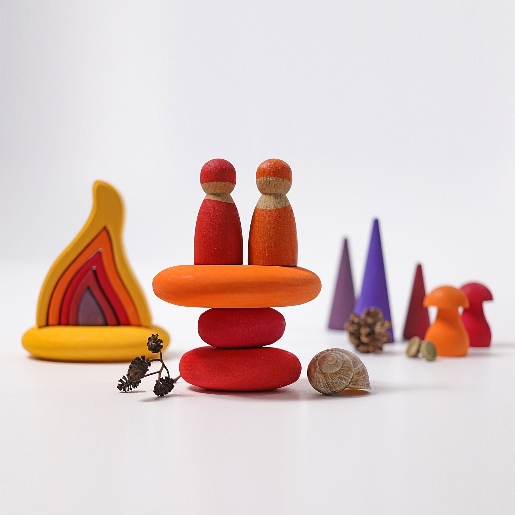Colorful wooden toy figures stacked on a white background