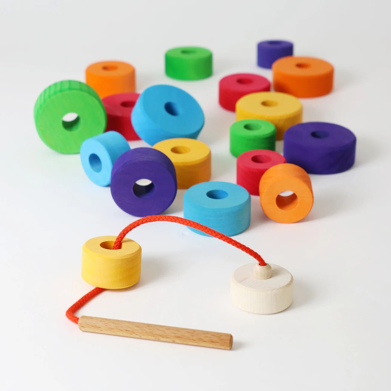 Colorful wooden rings with a string and wooden handle on a white background