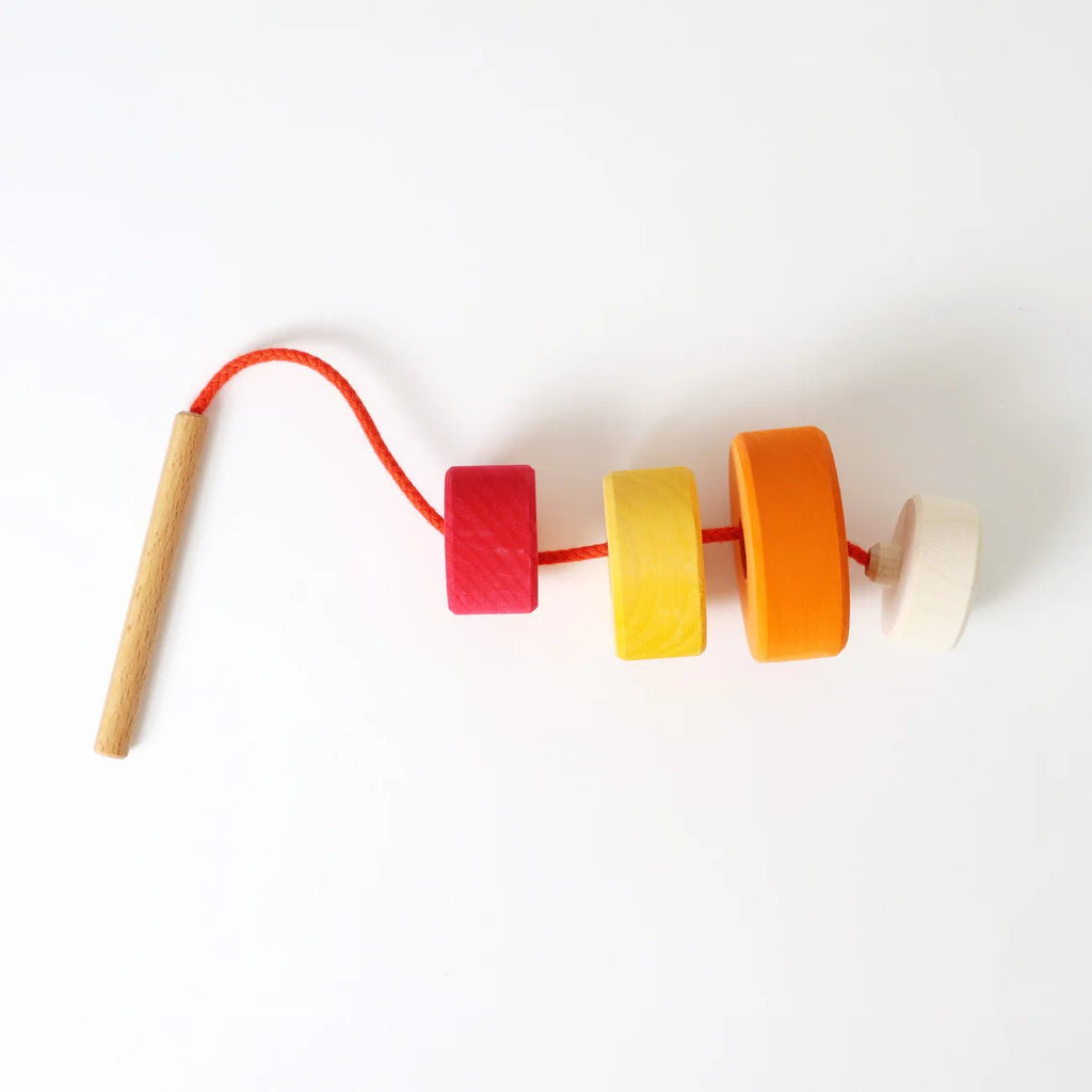 Colorful wooden beaded toy with a stick on a white background