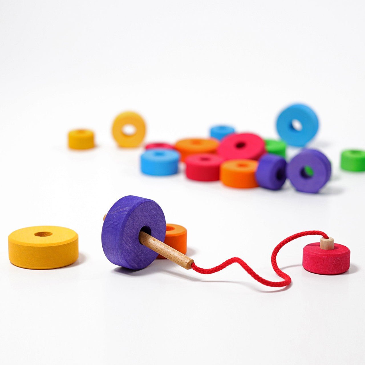 Colorful wooden toy with a pull string on a white background