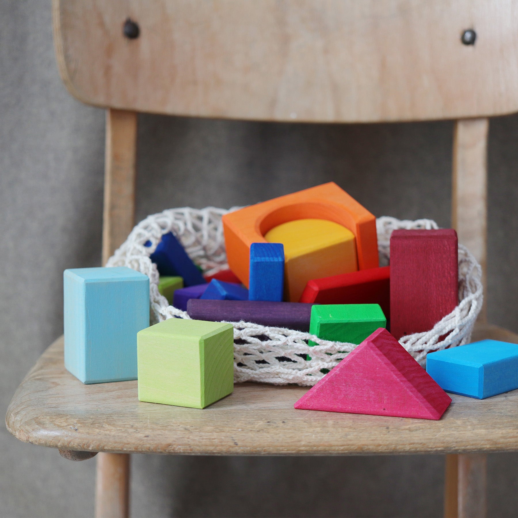Colorful wooden blocks on a wooden table with a basket in the background