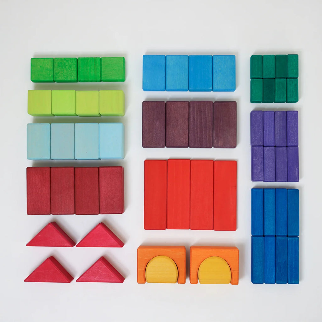 Set of colorful wooden blocks including cubes, rectangles, and triangles on a white background