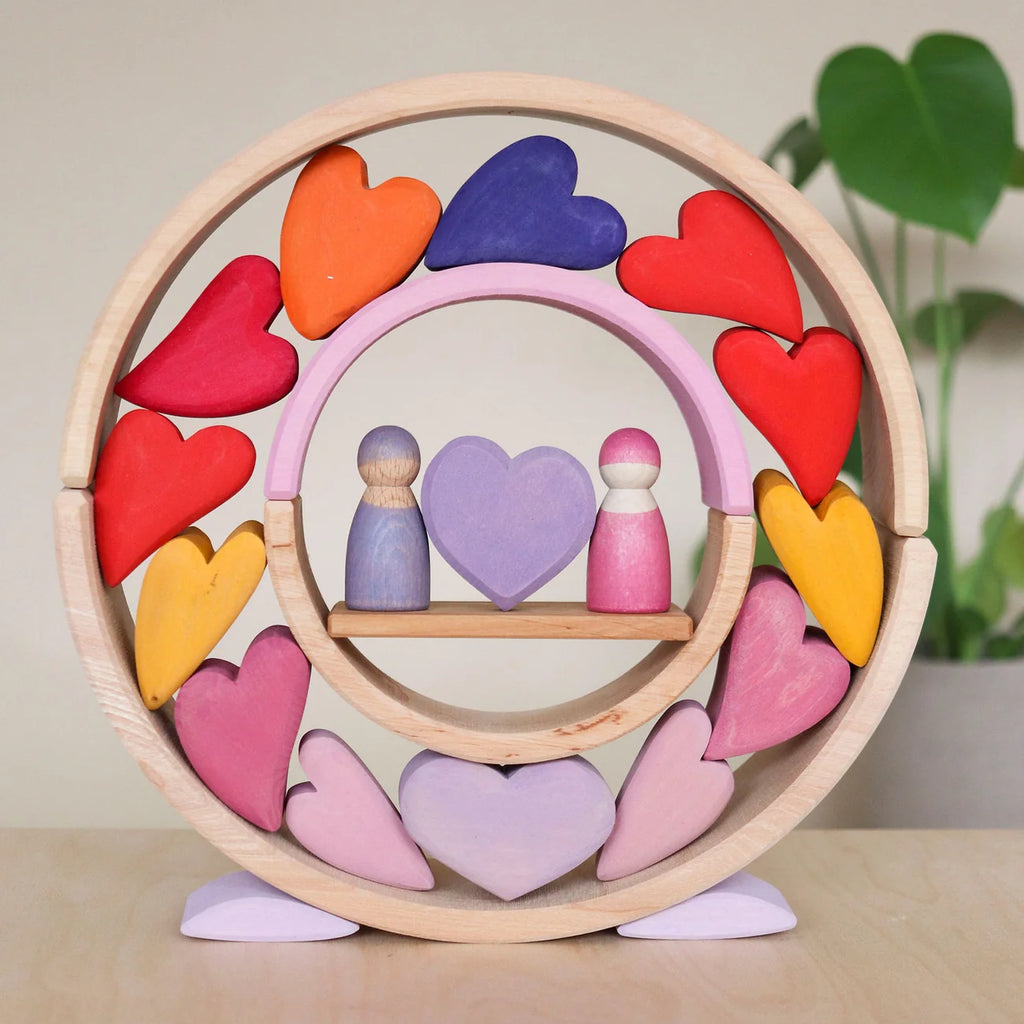 Wooden toy with colorful hearts and peg people on a neutral background