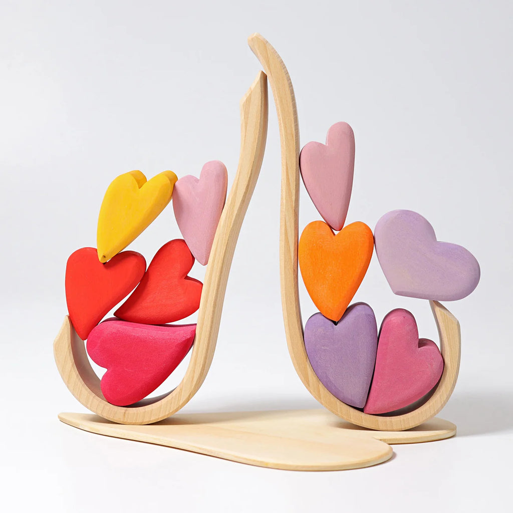 Colorful heart-shaped toy on a wooden stand against a white background