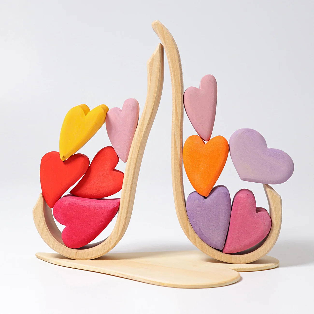 Colorful heart-shaped toy on a wooden stand against a white background