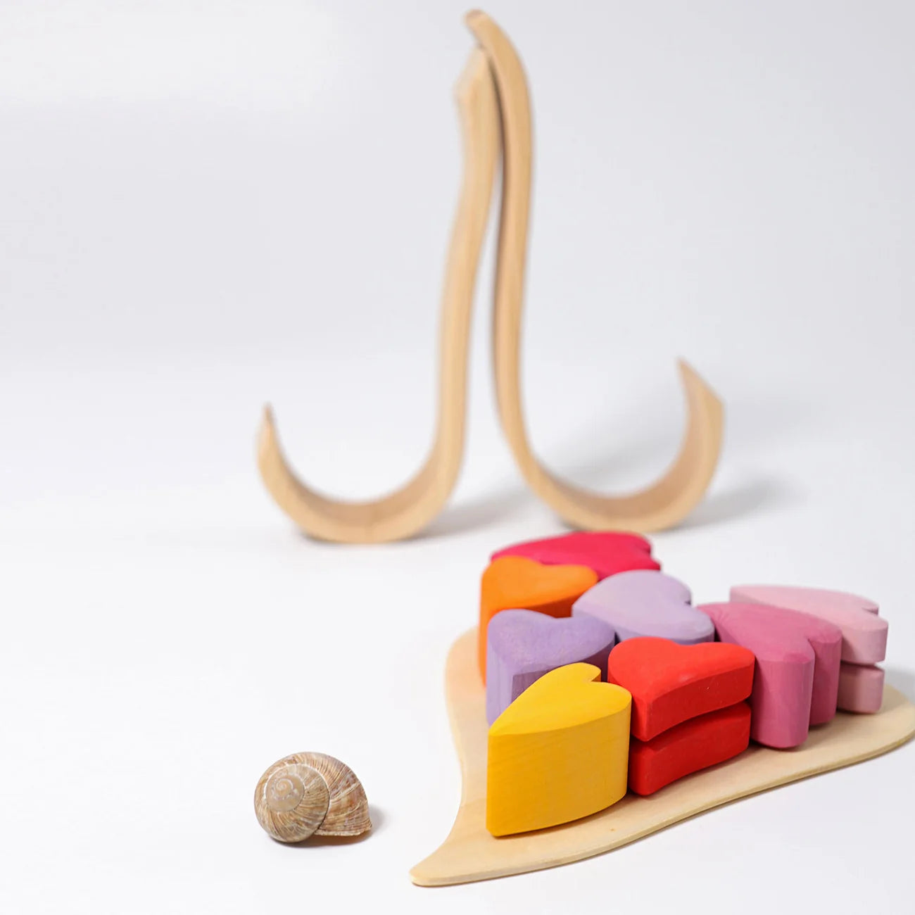 Colorful wooden heart-shaped blocks on a wooden stand with a white background