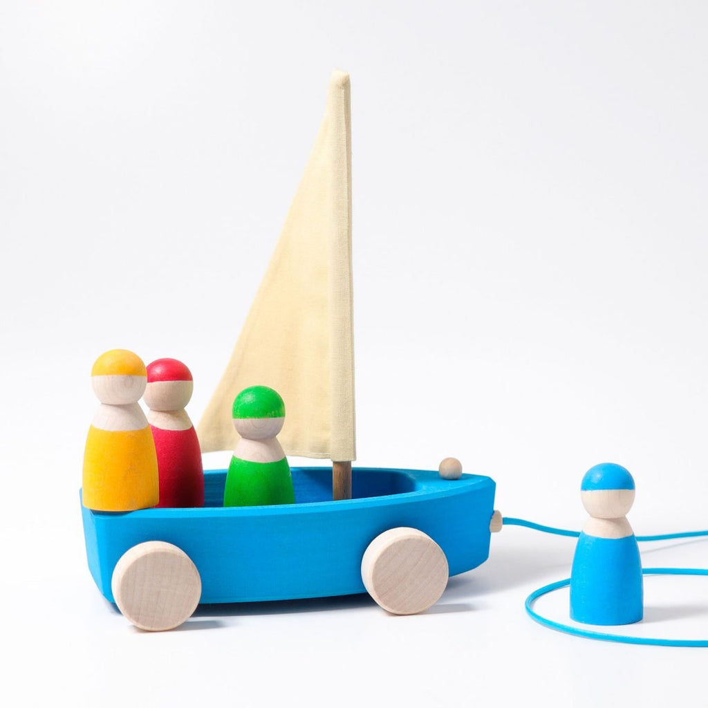 Colorful wooden toy boat with peg people on a white background