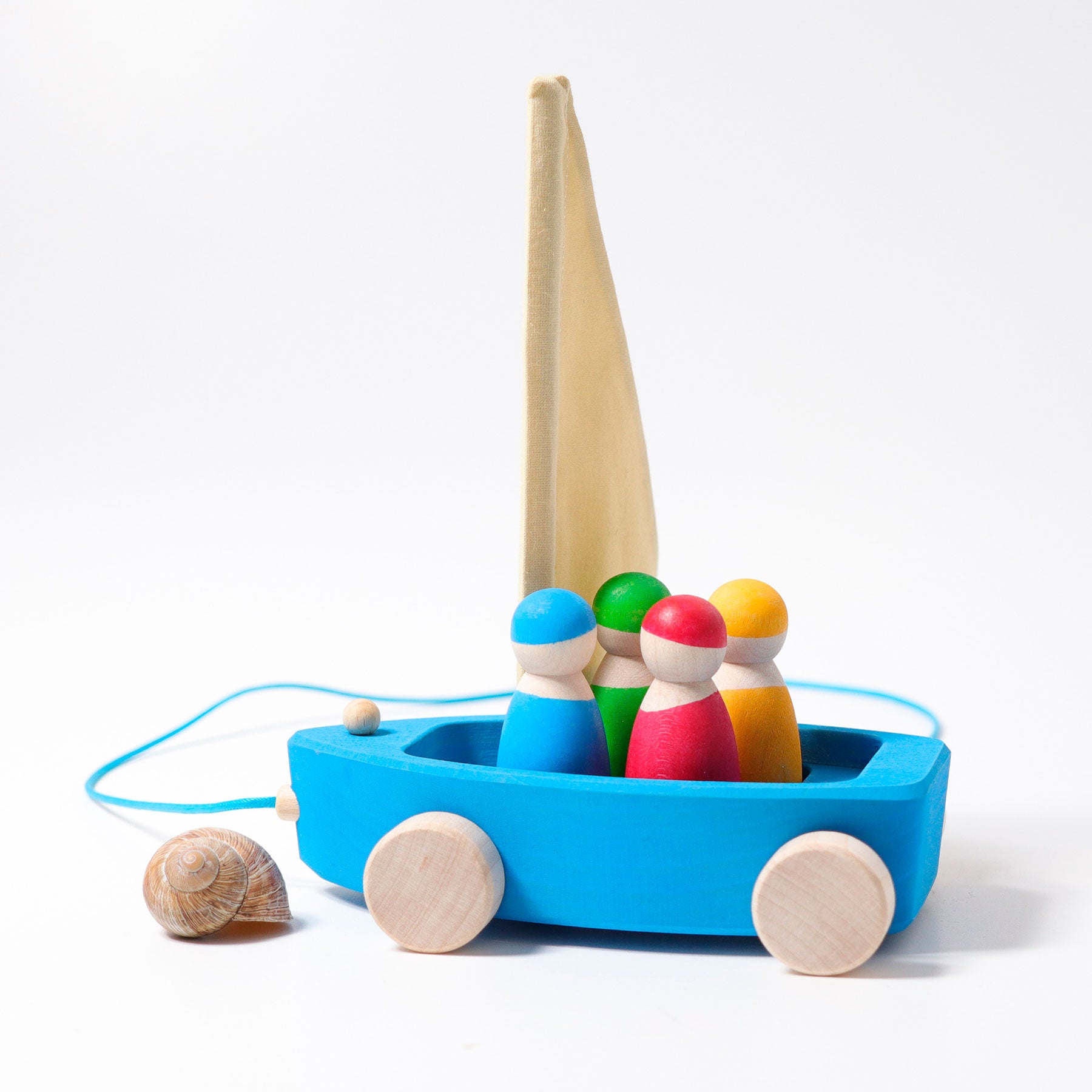 Colorful wooden toy boat with peg people and shells on a white background