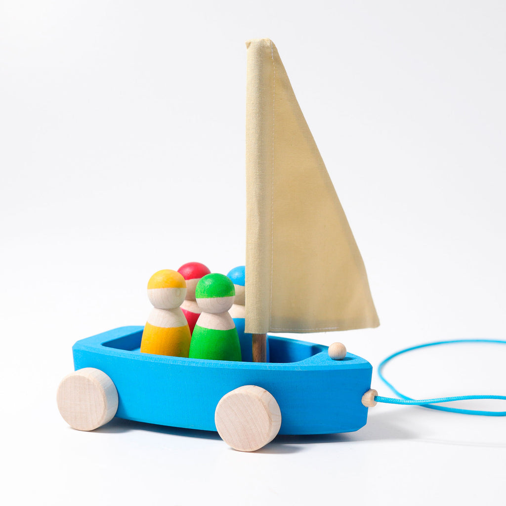 Colorful wooden toy boat with pull string on a white background