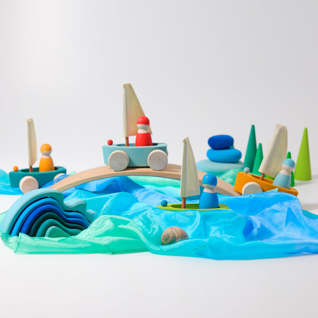 Toy boat set on a blue wavy surface with a white background