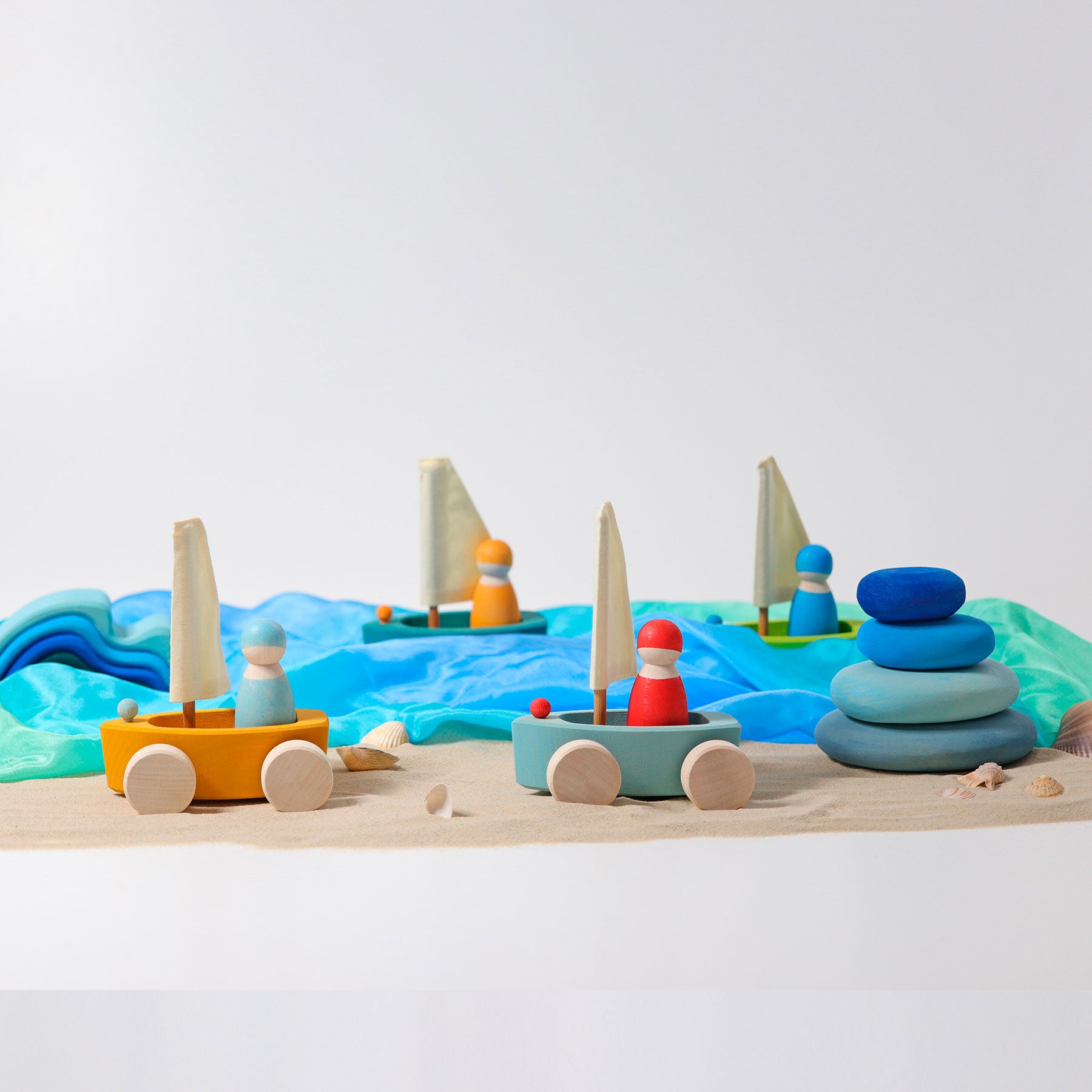 Colorful toy sailboats on a wooden surface with a minimalistic background