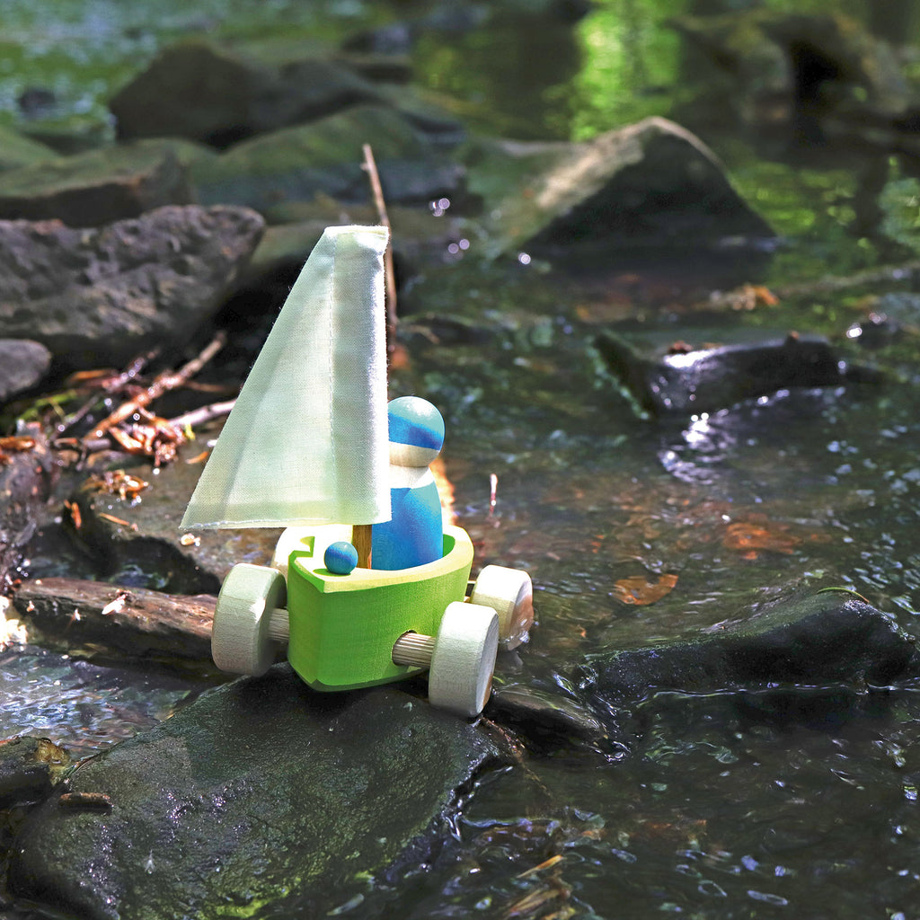 Toy sailboat with a figure on a rocky surface