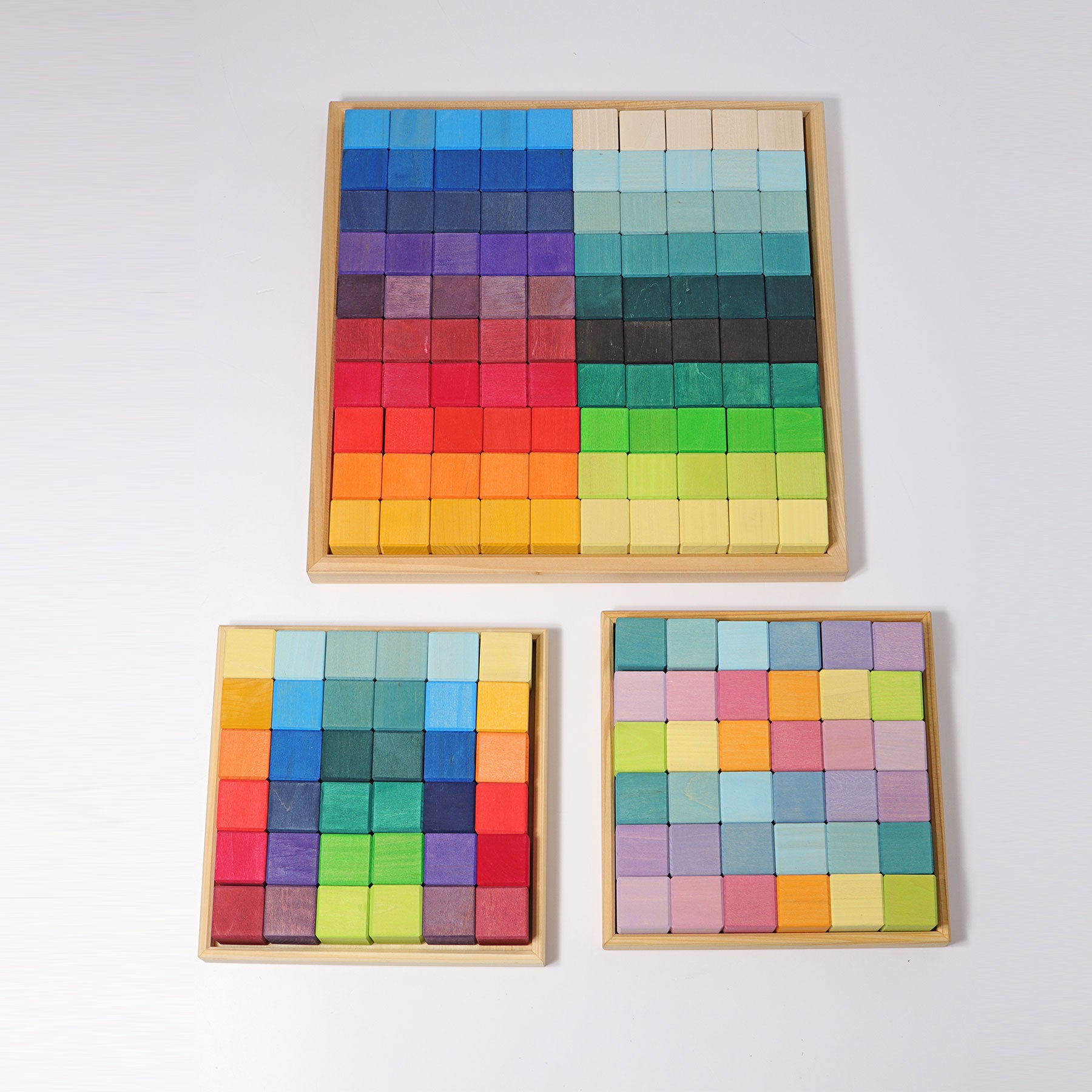 Set of three wooden color blocks with colorful square tiles on a white background