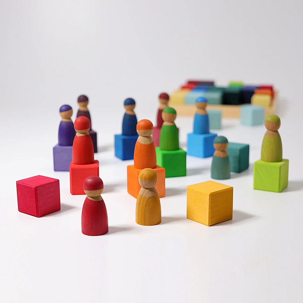 Colorful wooden peg people and blocks on a white background