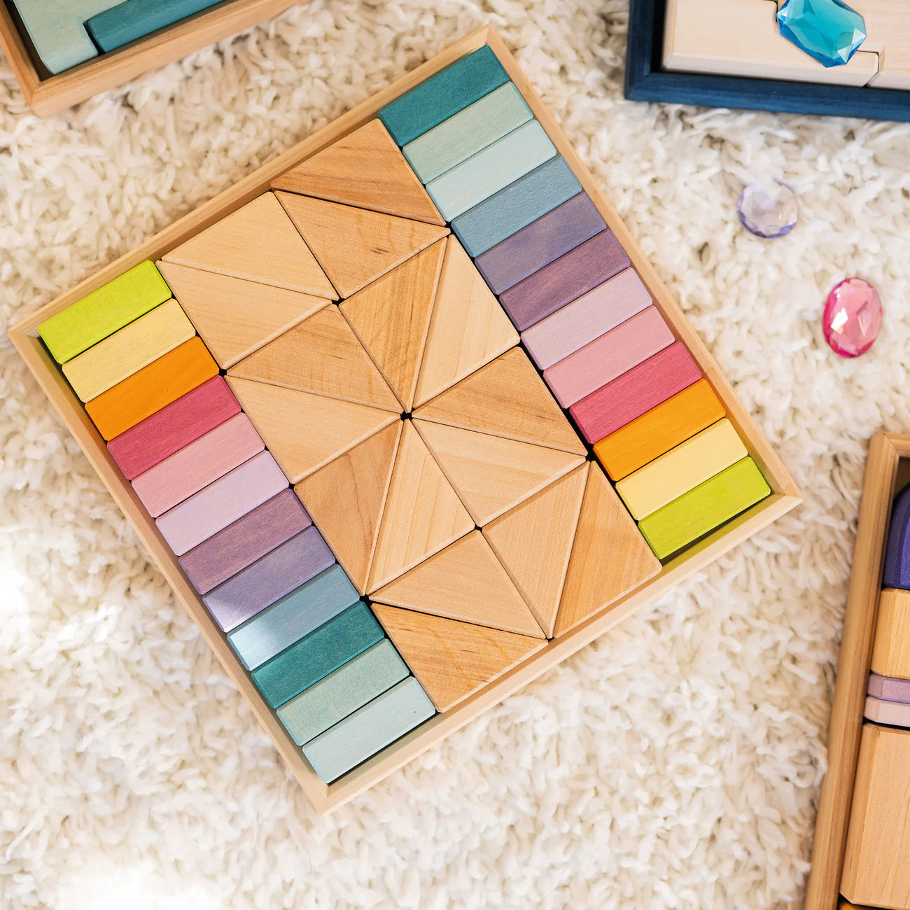 Colorful wooden tangram puzzle set on a textured surface