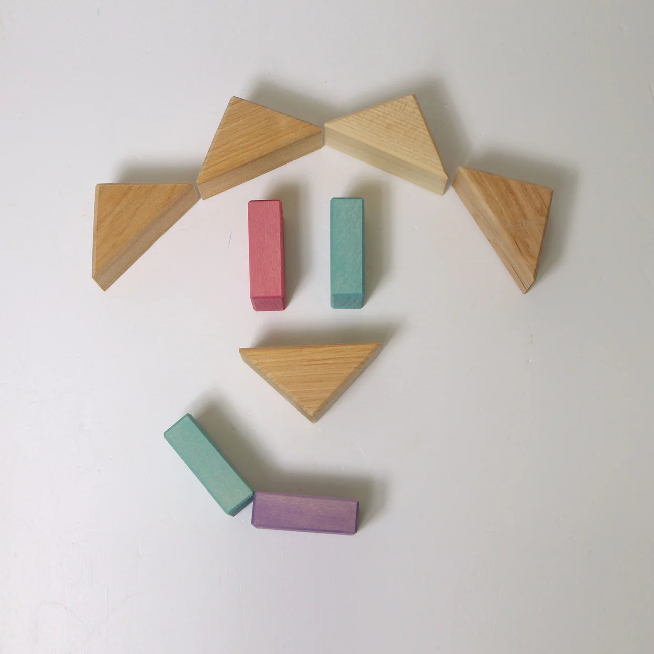 Wooden blocks with different shapes and colors arranged on a white background