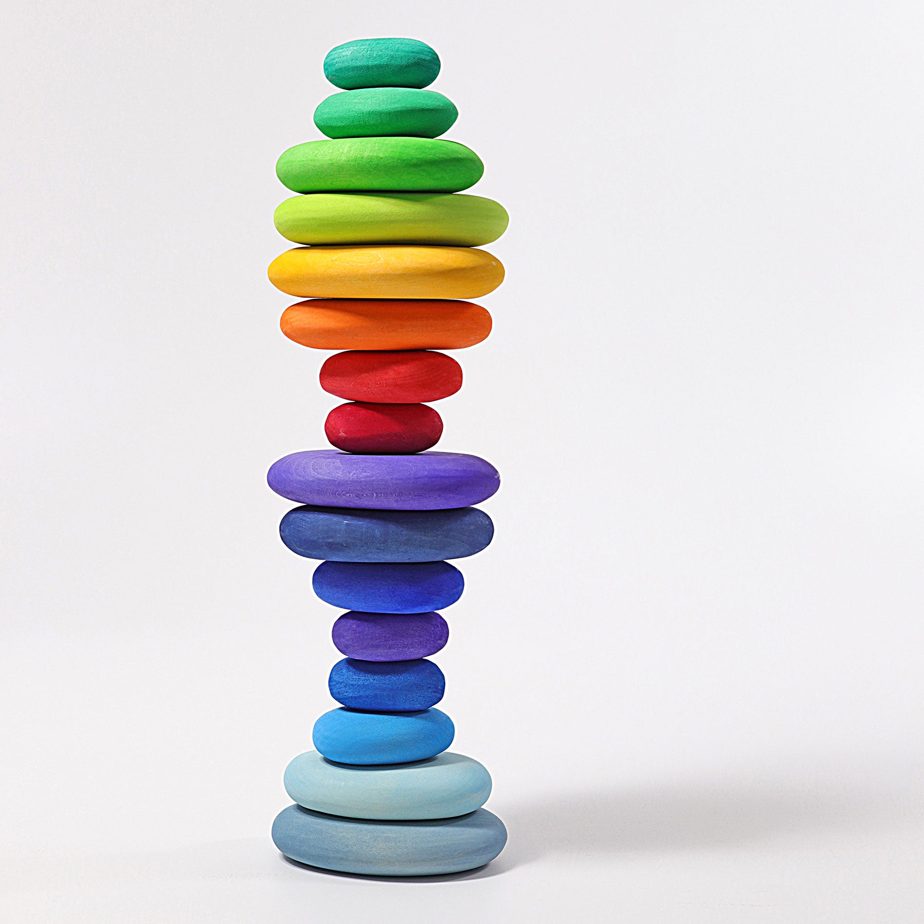 Stack of colorful stones in a rainbow pattern on a white background