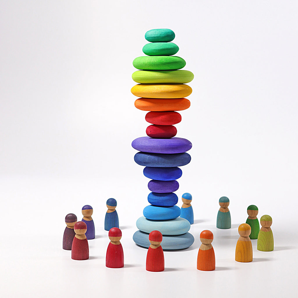 Colorful stacked stones and wooden figures on a white background
