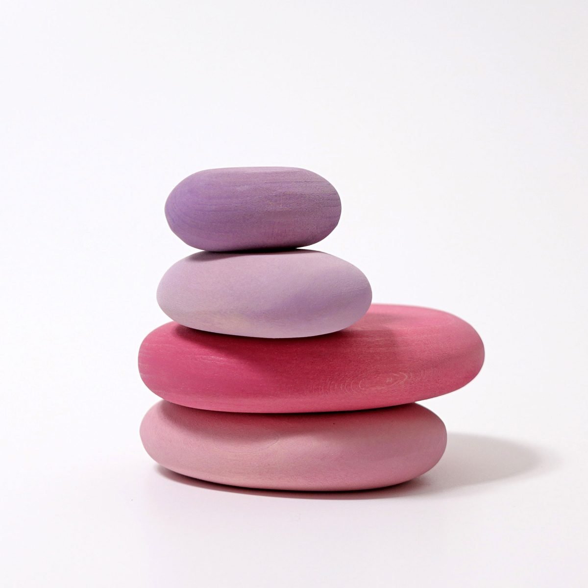 Stack of four pink and purple ombre stones on a white background