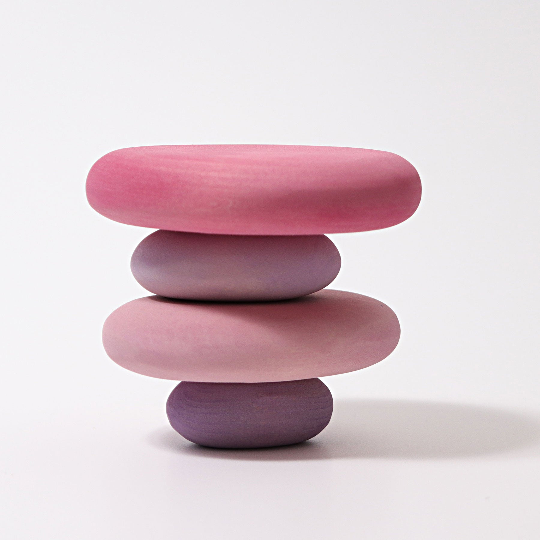 Stack of pink and purple ceramic bowls on a white background