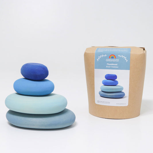 Stack of blue wooden toys next to their packaging on a white background