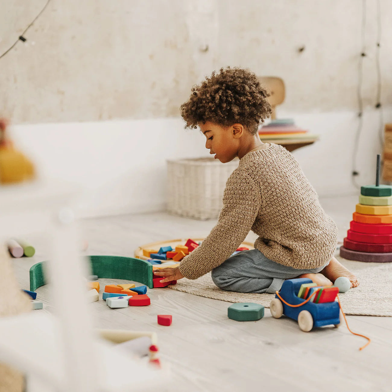 Child playing with toys on a light-colored floor