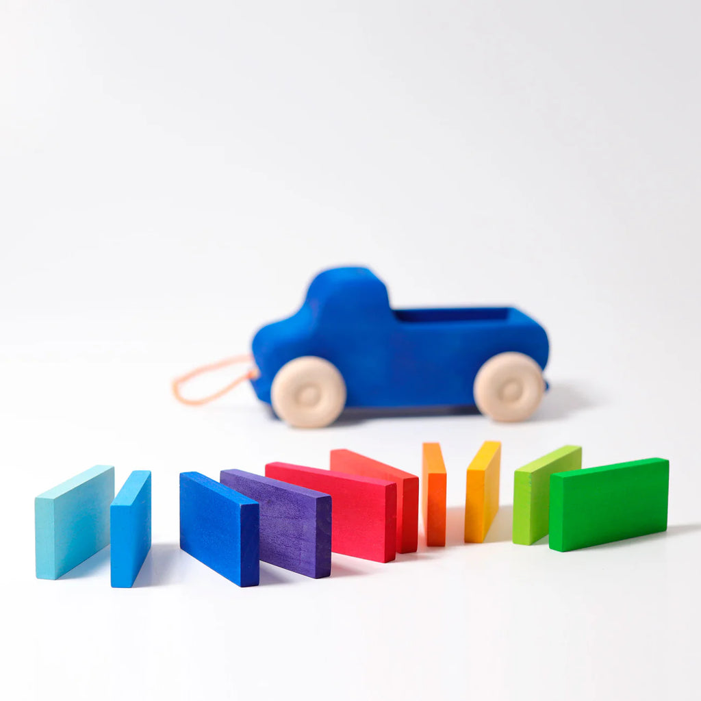 Colorful toy car and wooden blocks on a white background