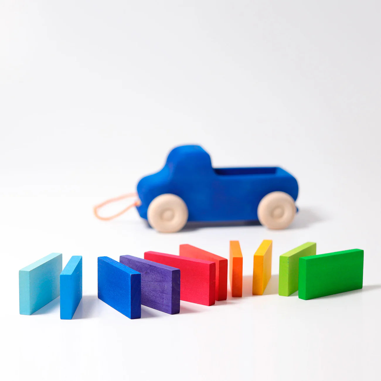Colorful toy car and wooden blocks on a white background