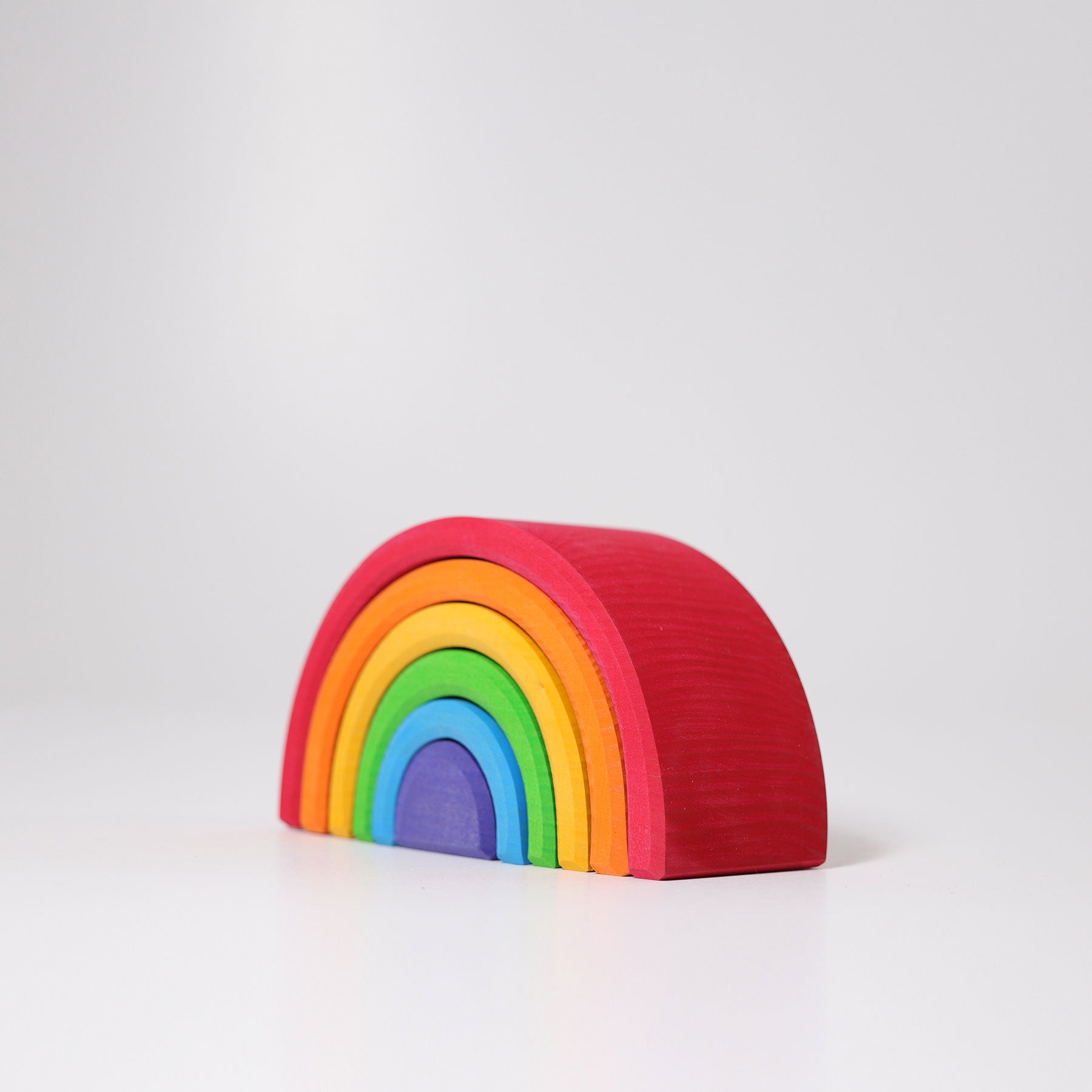 Colorful wooden rainbow toy on a white background