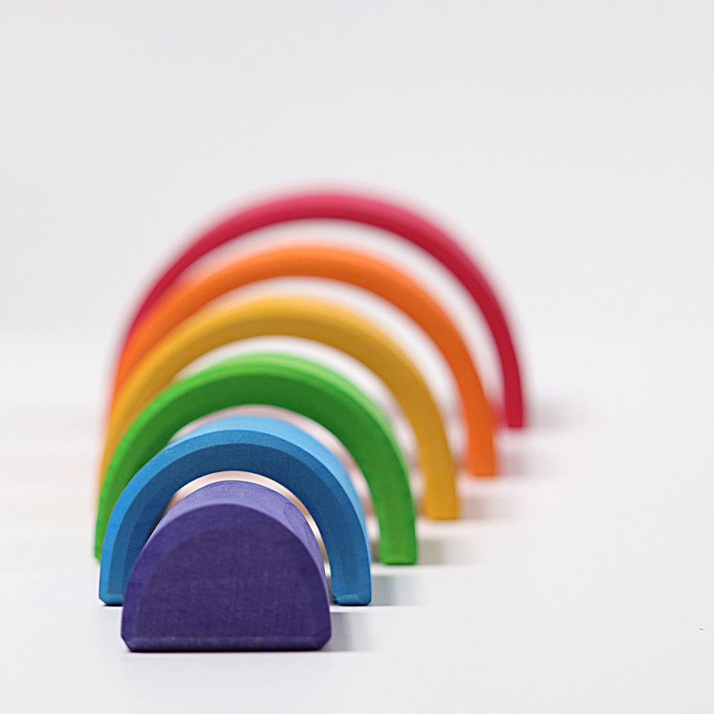 Set of colorful wooden rainbow toys on a white background