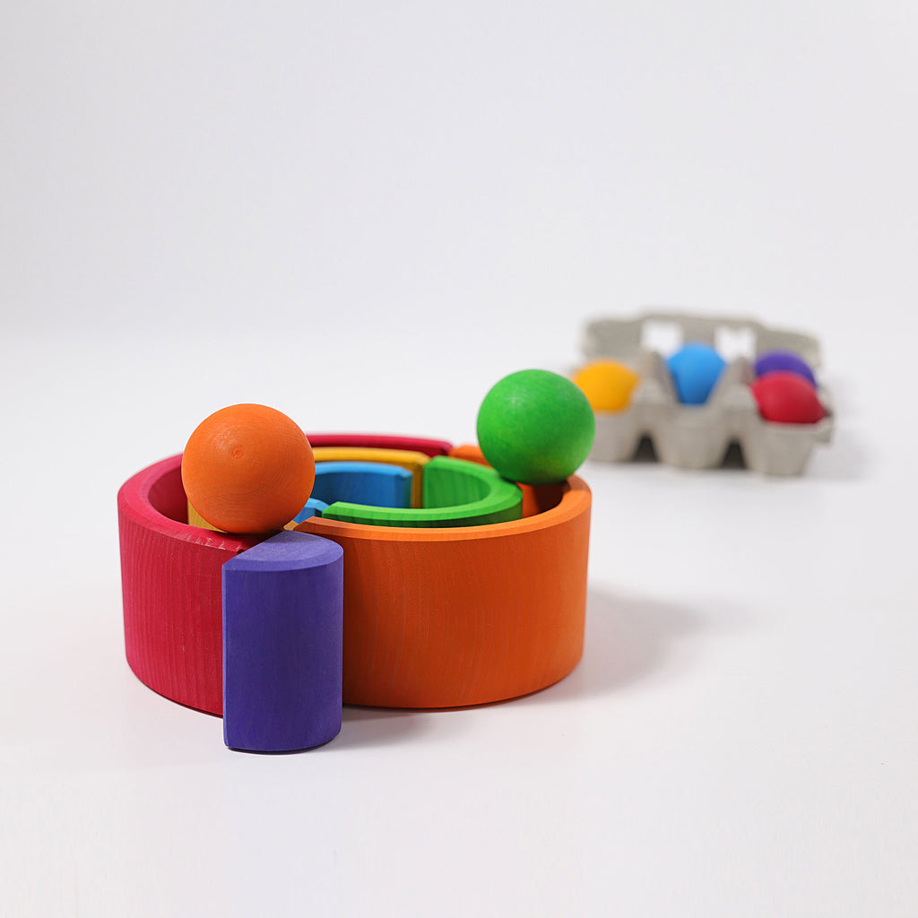 Colorful toy set with cylindrical and spherical shapes on a white background
