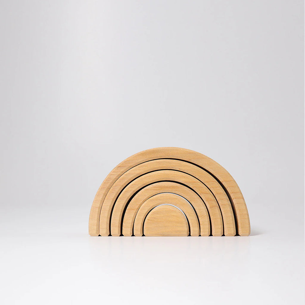 Set of wooden rainbow-shaped building blocks on a light gray background