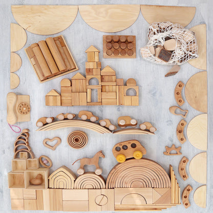 Collection of wooden building blocks and toys on a light gray background