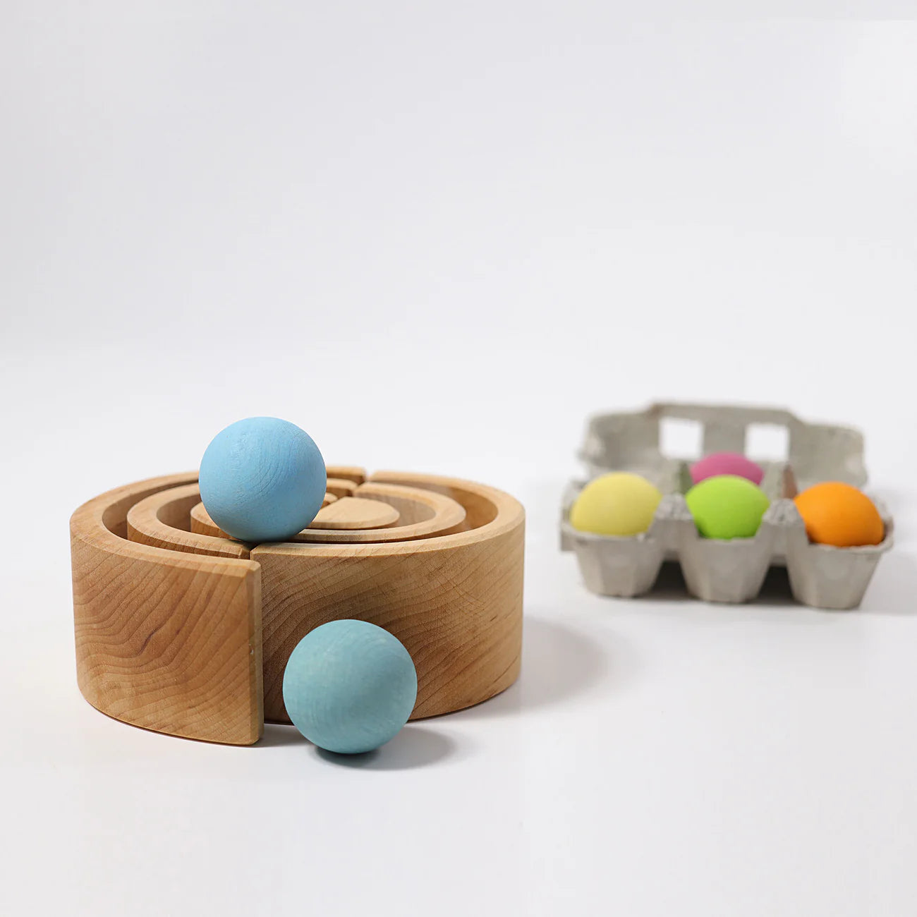 Wooden rainbow with blue balls and a carton of colorful Wooden Balls on a white background