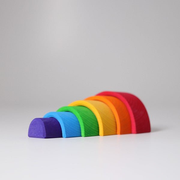 Set of rainbow-colored wooden blocks on a gray background