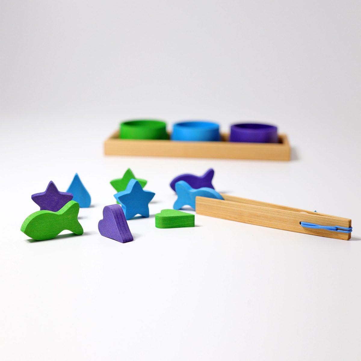 Colorful wooden shape sorting toy set on a white background