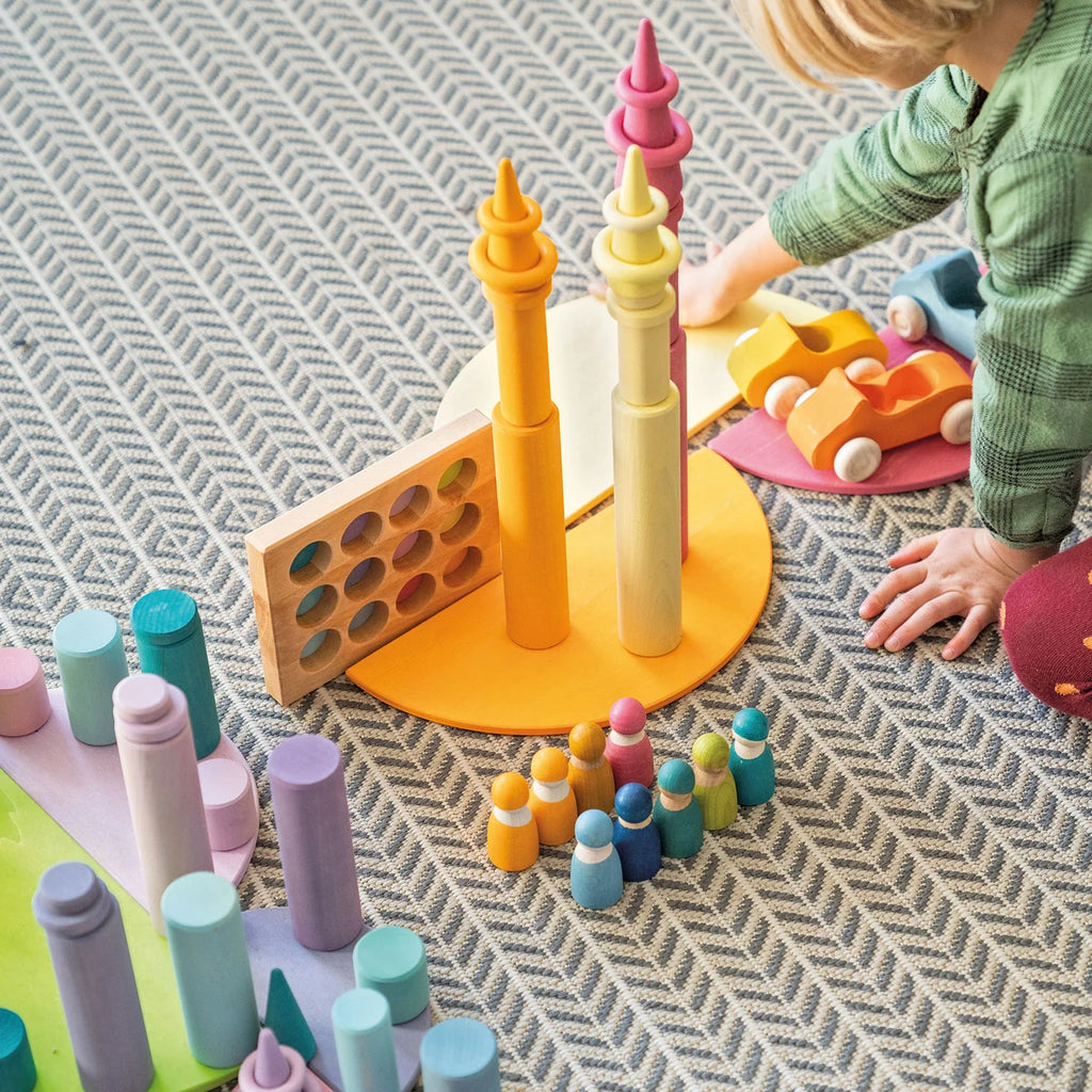 Child playing with colorful wooden toys on a textured surface