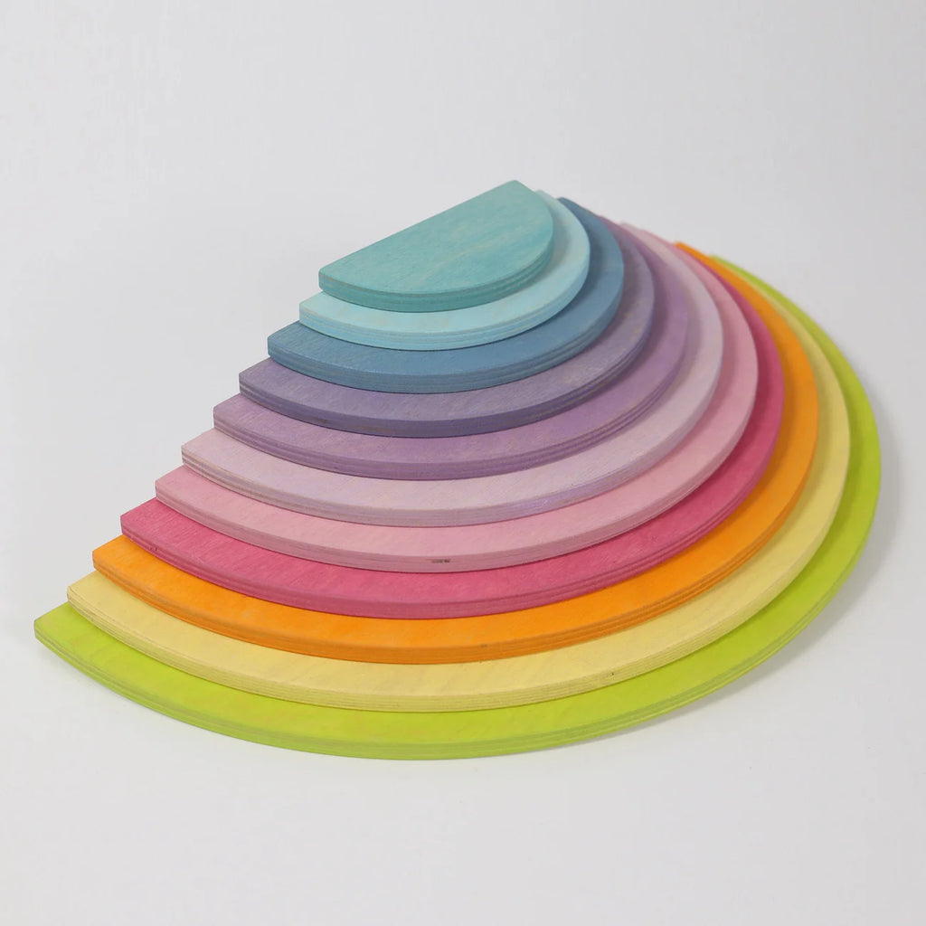 Set of colorful wooden rings stacked in a pyramid shape on a white background