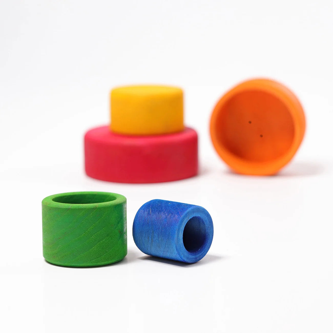 Colorful cylindrical wooden toys on a white background