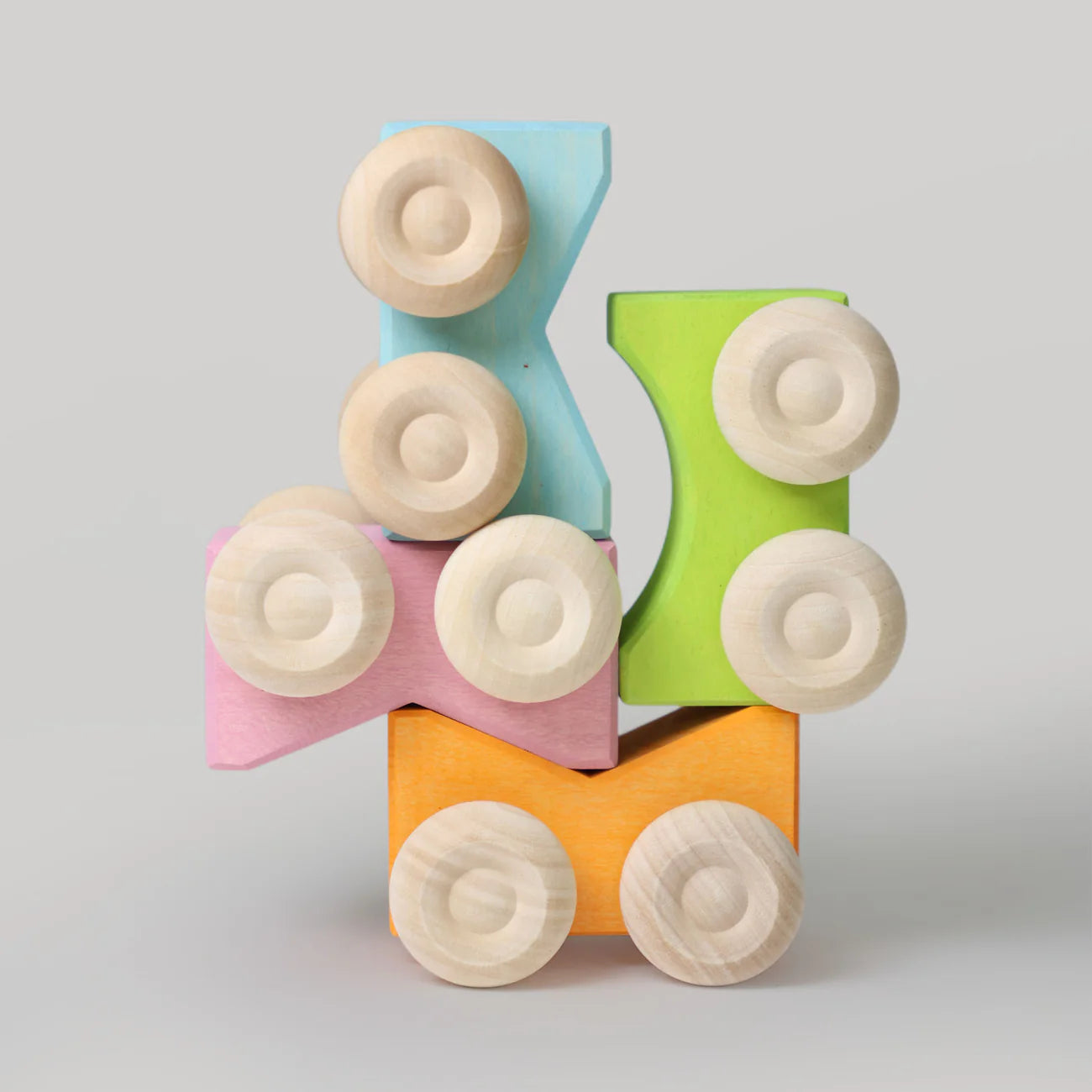 Colorful wooden cars stacked on a gray background
