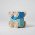 Wooden toy blocks with wheels on a light gray background